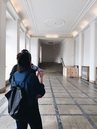 Rear view of woman standing in corridor