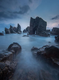 Scenic view of rocks in sea against sky