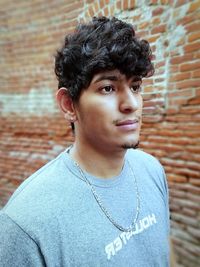 Portrait of young man standing against wall