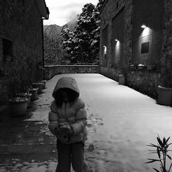 Girl walking on snowy footpath in city