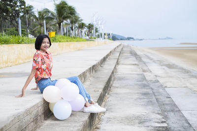 Asian young girl enjoy time playing balloone at the beach.