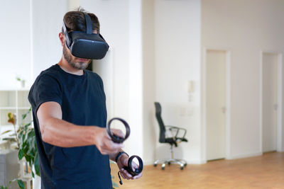 Man holding camera while standing at home