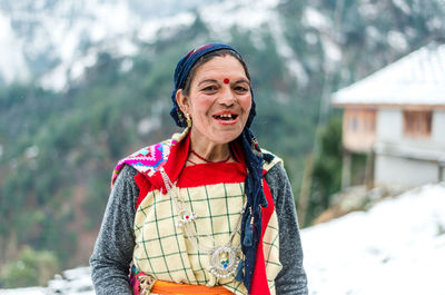 Portrait of smiling woman standing in snow