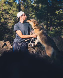 Man with dog sitting on tree