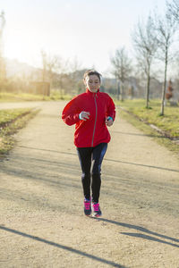 Mature woman running on road in park