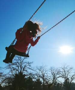 Low angle view of swing at playground against sky