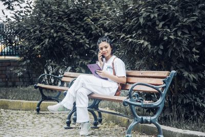 Woman sitting on bench in park