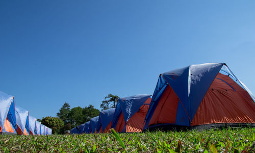 Tent on field against clear blue sky