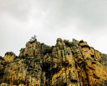 Low angle view of rocky mountain against sky