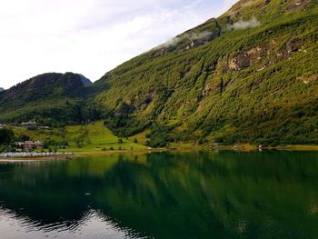 Scenic view of lake by mountains against sky