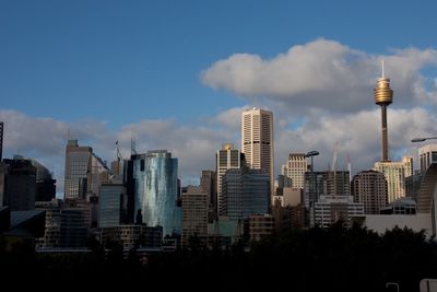 Low angle view of modern buildings against cloudy sky