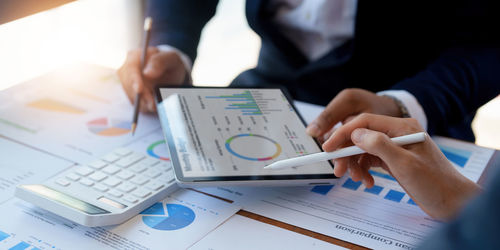 Midsection of businessman working on table