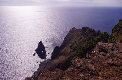 High angle view of crab on cliff by sea against sky