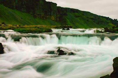 Scenic view of waterfall against sky