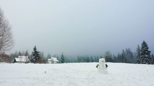 Snowman on field against sky