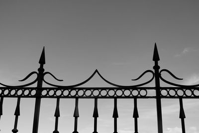 Low angle view of metal fence against sky