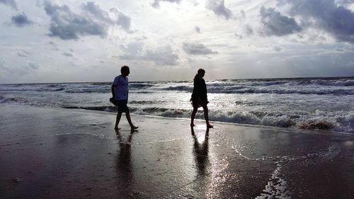 Rear view of two people on beach