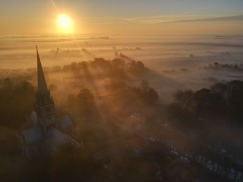 Aerial view of buildings against sky during sunset