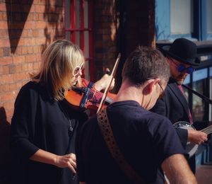 Rear view of men playing at music concert