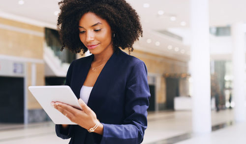 Smiling businesswoman using digital tablet outdoors