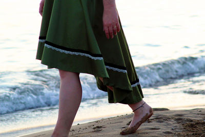 Low section of woman walking at beach