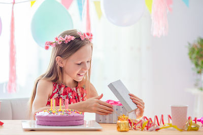 Woman looking away while holding ice cream on table