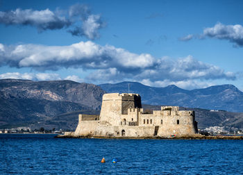 Buildings by sea against sky