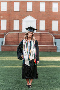 Full length of young woman standing on grass