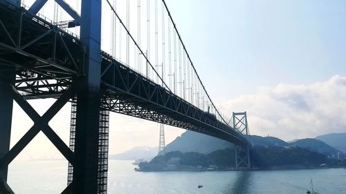 View of suspension bridge against cloudy sky