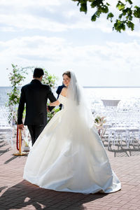 Portrait of bride and groom standing at beach