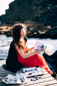 Midsection of woman sitting outdoors