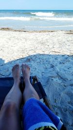 Low section of woman relaxing on beach