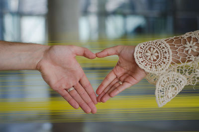 Close-up of couple making heart shape with hands