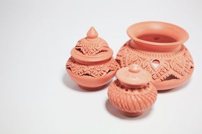 High angle view of earthenware containers on white background