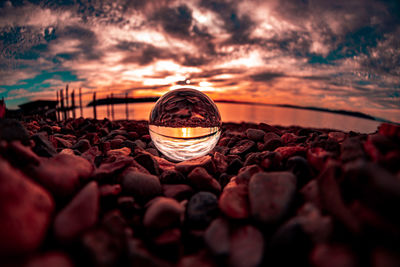 Close-up of crystal ball on rock during sunset