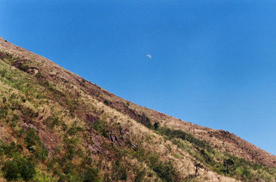 Low angle view of mountain against clear blue sky