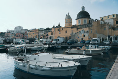 Boats moored in canal by buildings in city