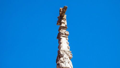 Low angle view of tree trunk against clear blue sky