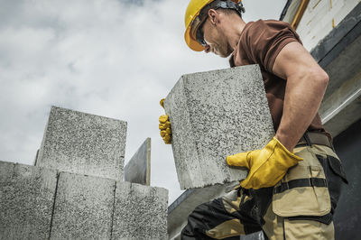 Low angle view of man standing against wall