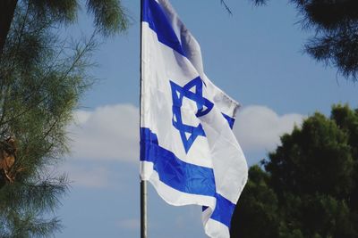 Low angle view of flag against blue sky