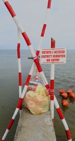 Sign on railing in sea