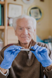 Portrait of man showing blood sample