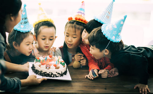 Cute happy friends enjoying birthday party at home