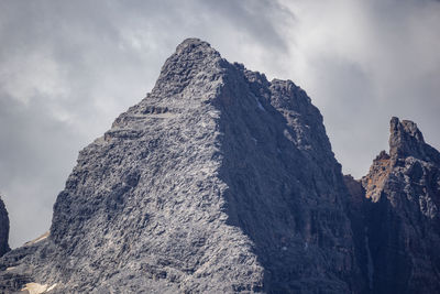 Low angle view of rocky mountain against sky