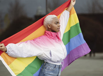 Confident lgbtqia woman holding rainbow flag