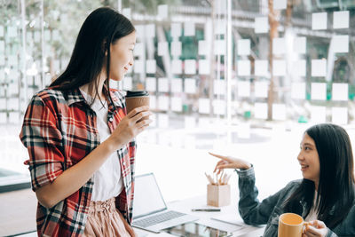 Young woman drinking coffee at table