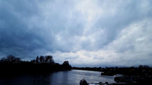 Scenic view of river against cloudy sky