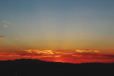 Low angle view of airplane flying against sky during sunset