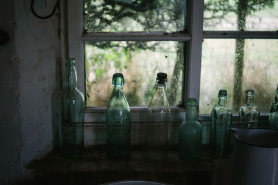 Close-up of bottles on window