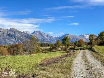 Road leading towards mountains against sky